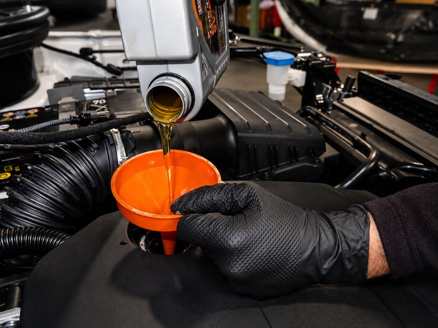 Frisches Motoröl wird beim Ölwechsel über einen Trichter eingefüllt